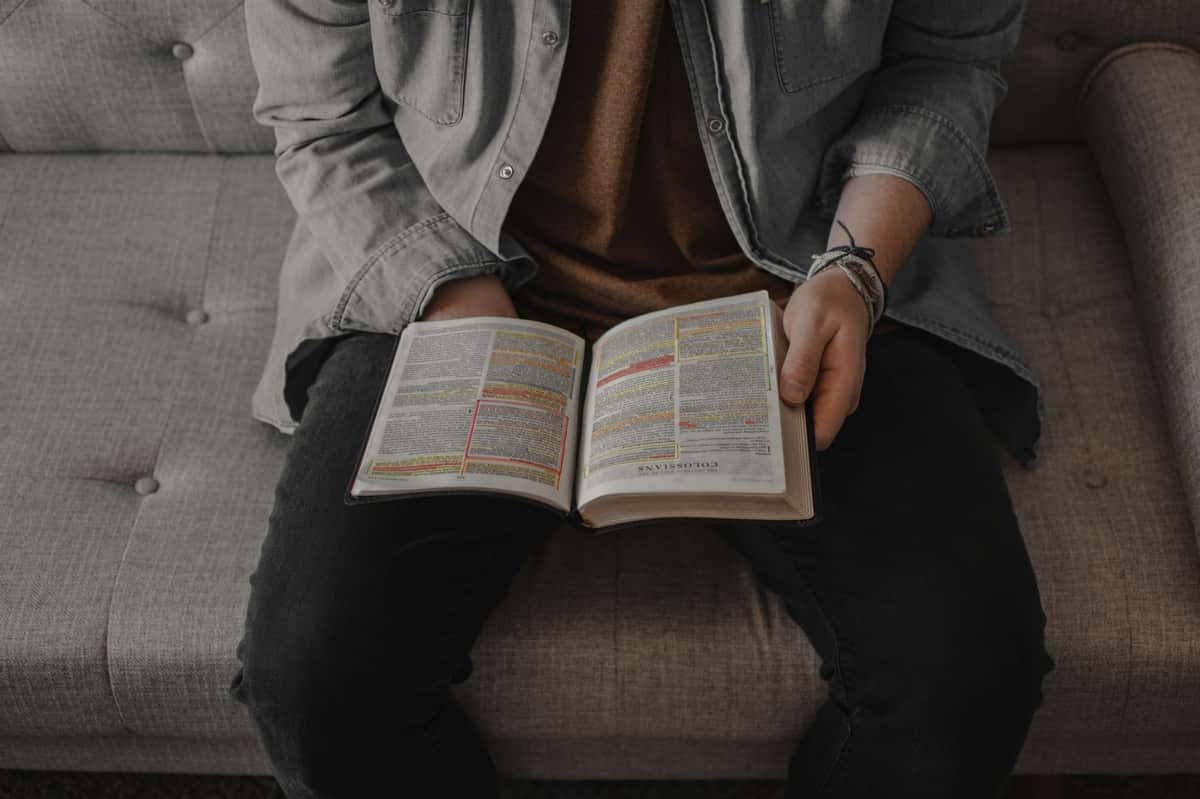 Person reading an open Bible.